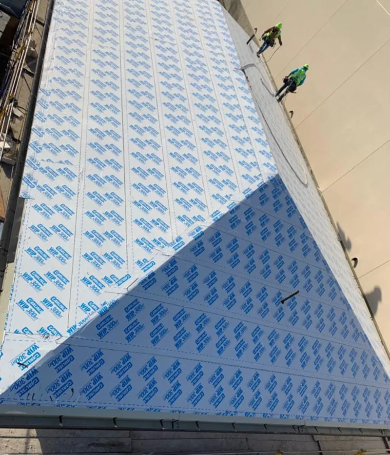 Professional roofers installing underlayment on a metal roof in Kings Park West